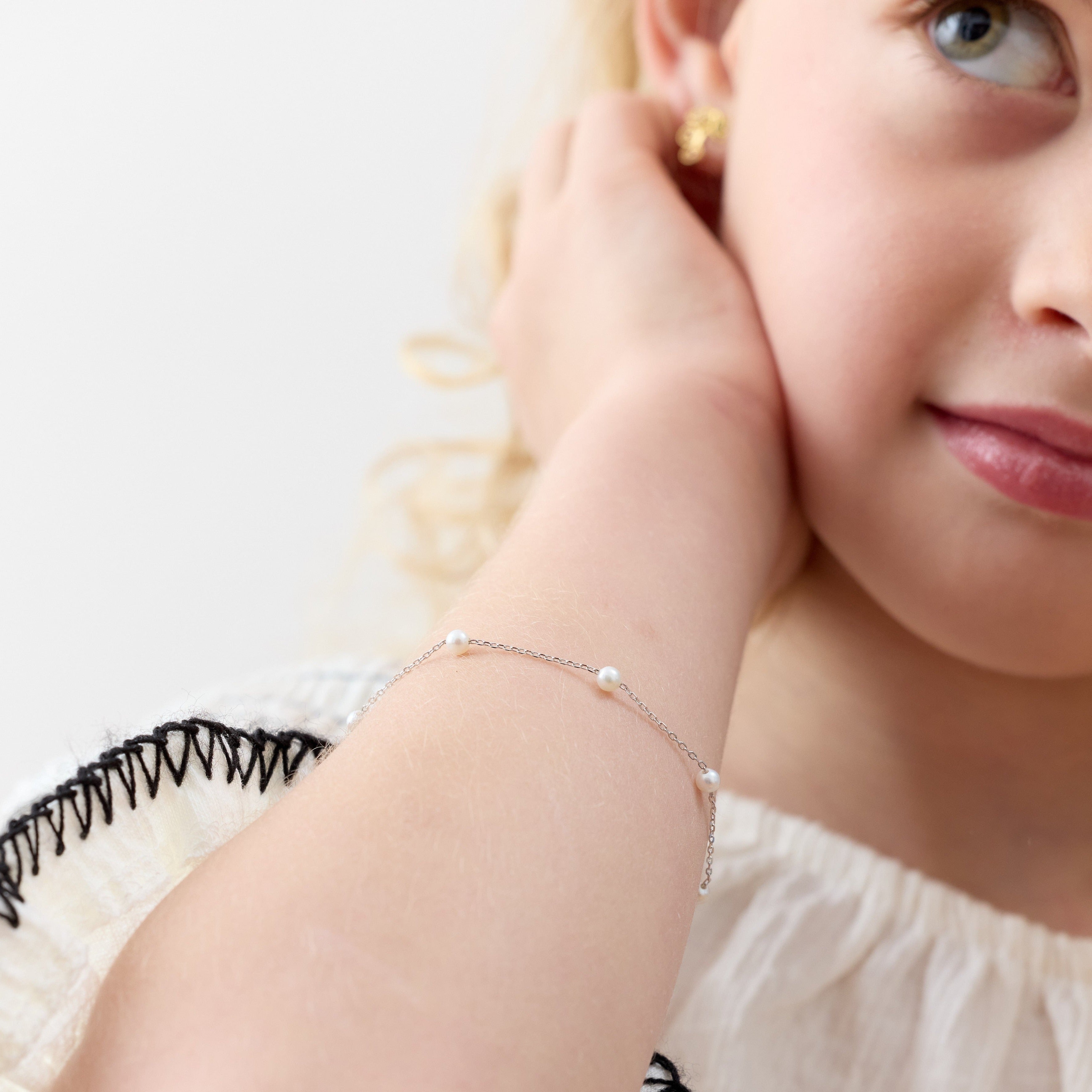 Niña con pulsera de plata 925 con perlas cultivadas, hipoalergenica y libre de nickel