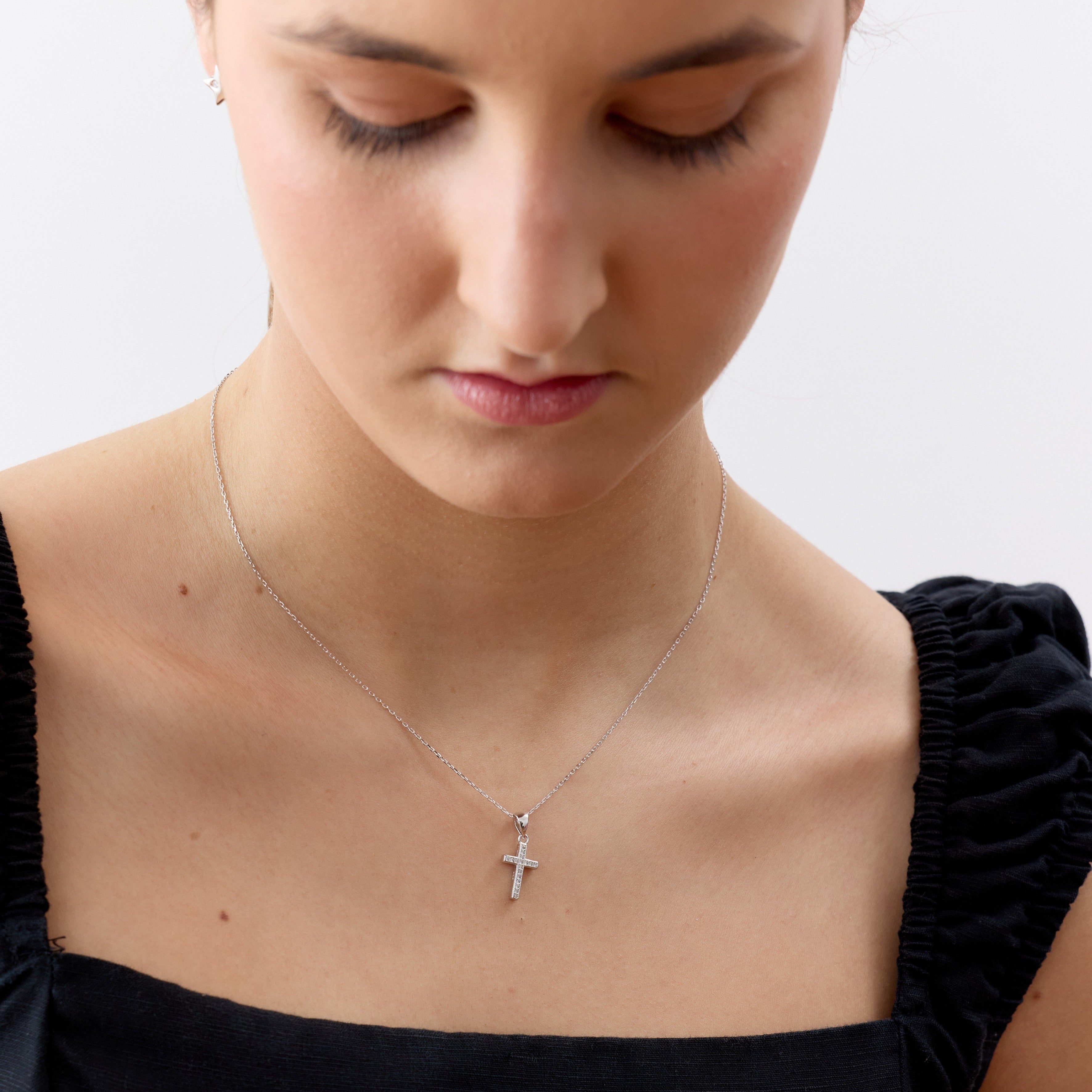 Modelo con collar religioso de cruz en plata 925 con circones transparentes, regalo primera comunion